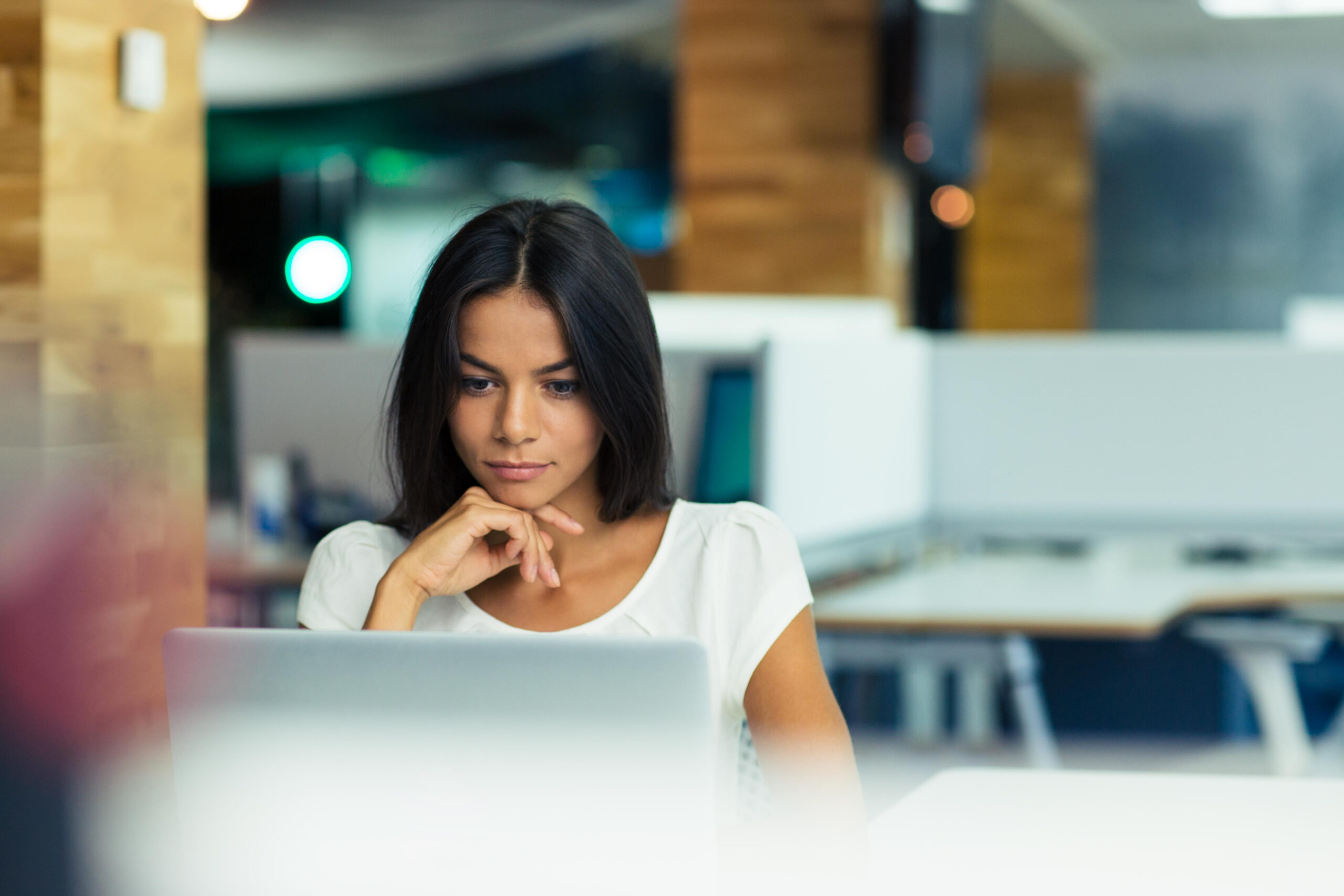 Image of a woman studying her computer for a blog post from Pacific Coast Advertising about AI