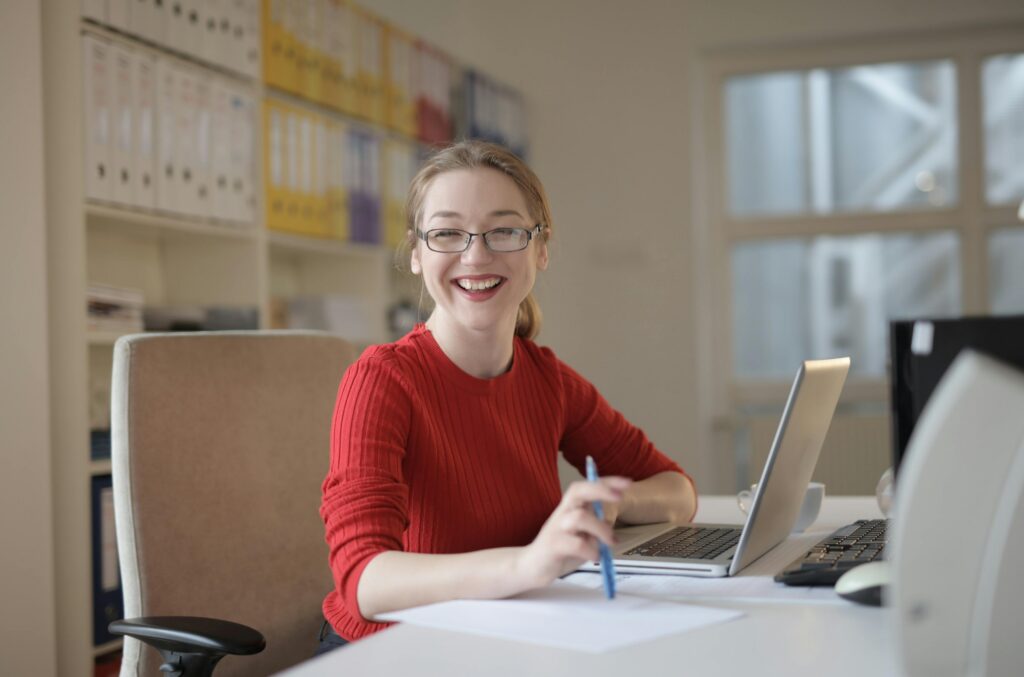 Image of a woman at a computer for a blog post from Pacific Coast Advertising about how AI misinformation is changing how businesses communicate online and what businesses can do to protect accuracy, trust, SEO, and AEO. Image by Andrea Piacquadio